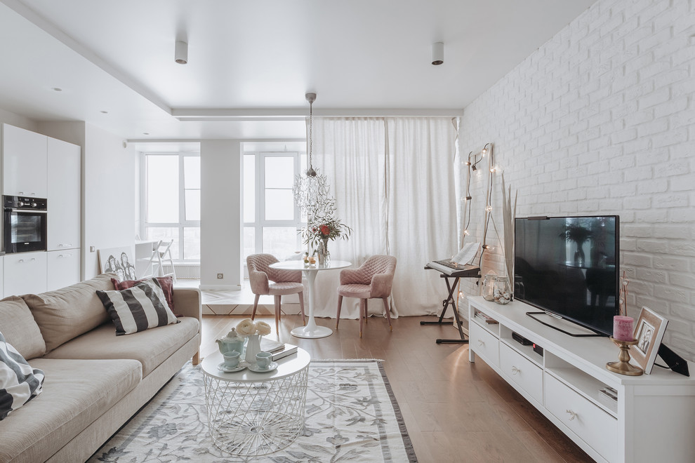 Photo of a small scandinavian open concept family room in Moscow with white walls, medium hardwood floors, no fireplace, a freestanding tv and beige floor.