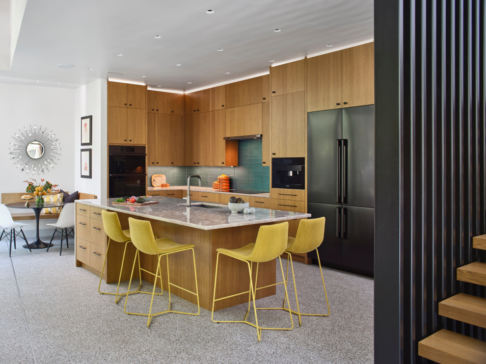 Midcentury single-wall open plan kitchen in Austin with an undermount sink, flat-panel cabinets, medium wood cabinets, quartzite benchtops, glass tile splashback, black appliances, with island and white benchtop.