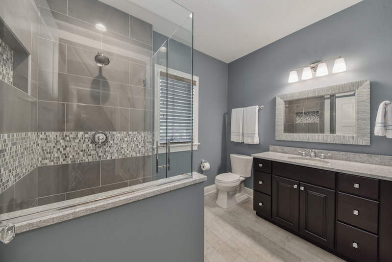 Mid-sized transitional 3/4 bathroom in Chicago with raised-panel cabinets, dark wood cabinets, an alcove shower, a two-piece toilet, beige tile, black tile, blue tile, gray tile, mosaic tile, grey walls, porcelain floors, an undermount sink and granite benchtops.