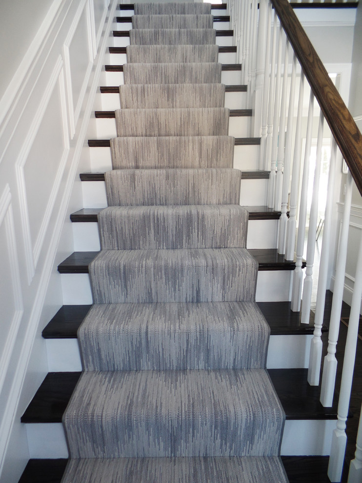 This is an example of a mid-sized transitional wood straight staircase in Boston with painted wood risers.