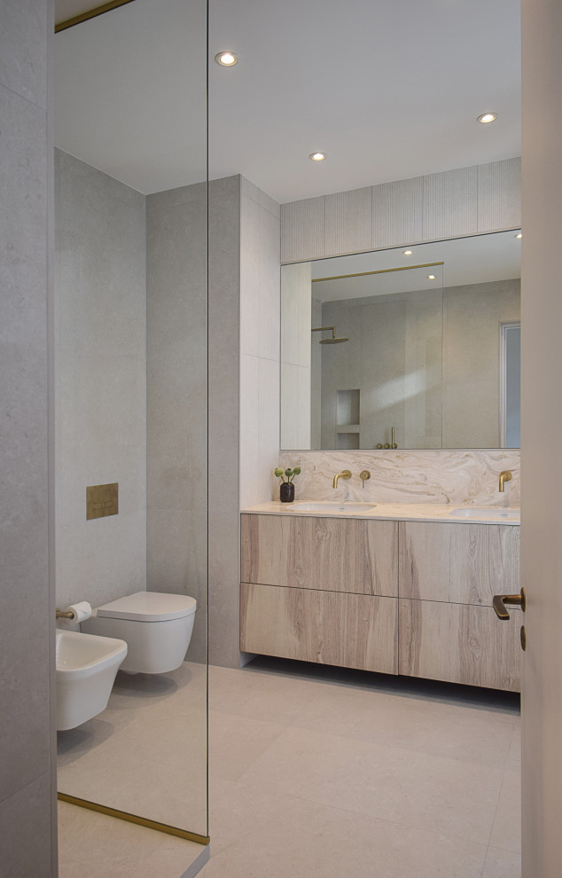 Inspiration för ett stort funkis vit vitt en-suite badrum, med släta luckor, skåp i ljust trä, en kantlös dusch, en vägghängd toalettstol, beige kakel, stenkakel, vita väggar, ett integrerad handfat, marmorbänkskiva och med dusch som är öppen