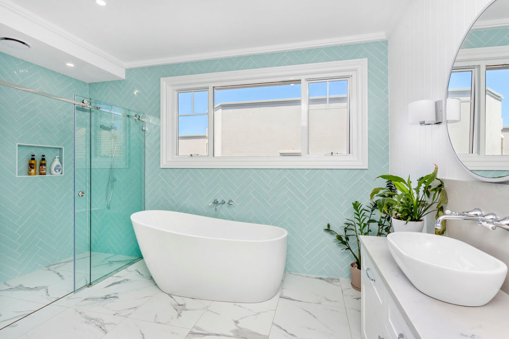 Immagine di una stanza da bagno con doccia minimalista di medie dimensioni con ante lisce, ante blu, vasca freestanding, un lavabo e mobile bagno sospeso