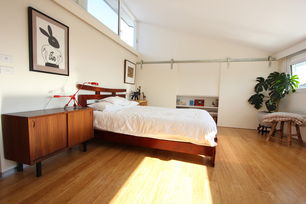 Foto de dormitorio principal escandinavo de tamaño medio sin chimenea con paredes blancas, suelo de bambú y suelo marrón
