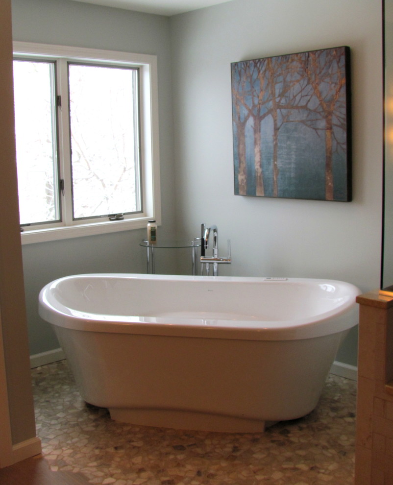 Transitional pebble tile floor and beige floor freestanding bathtub photo in Boston with gray walls