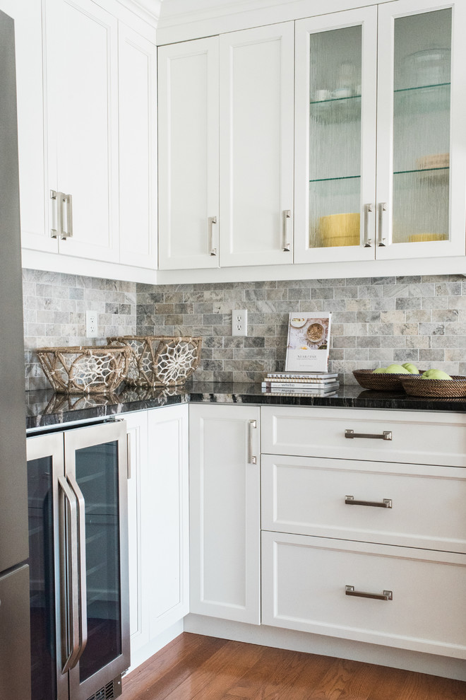 Example of a transitional kitchen design in Toronto with recessed-panel cabinets, white cabinets, granite countertops and an island