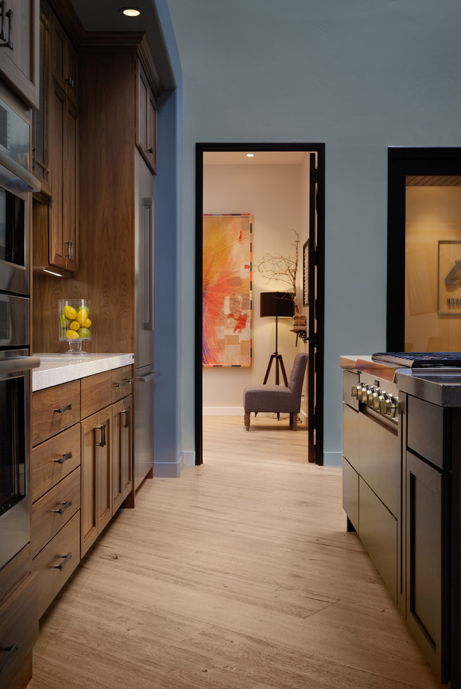 Example of a mid-sized transitional galley light wood floor and beige floor eat-in kitchen design in San Francisco with a double-bowl sink, dark wood cabinets, quartzite countertops, white backsplash, ceramic backsplash, stainless steel appliances and an island