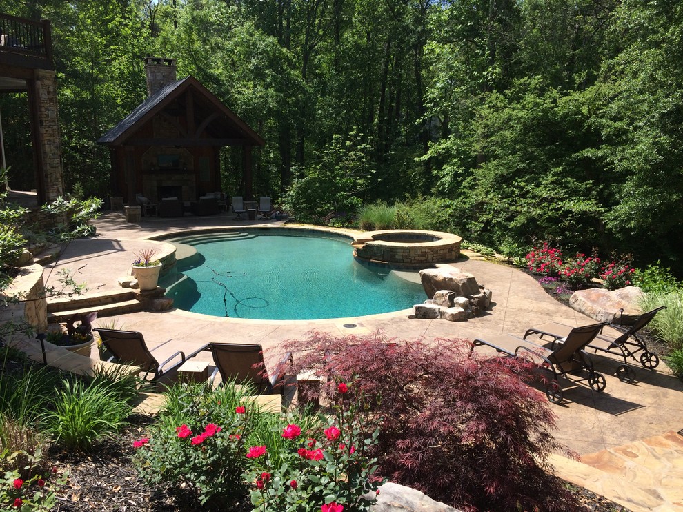 Example of a mountain style backyard concrete paver and kidney-shaped natural hot tub design in Atlanta