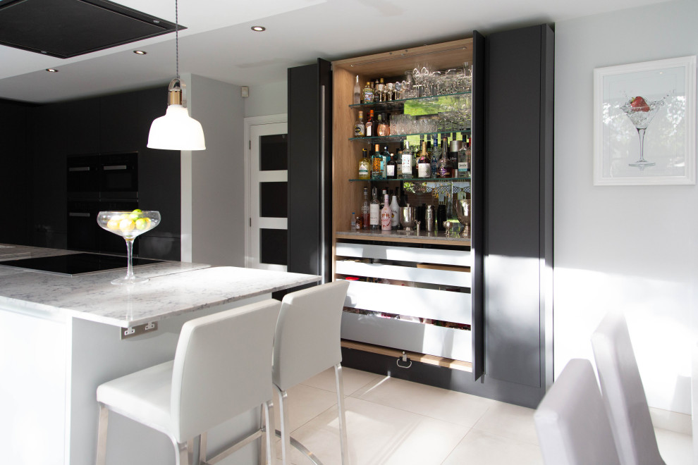 Large contemporary open plan kitchen in London with flat-panel cabinets and with island.