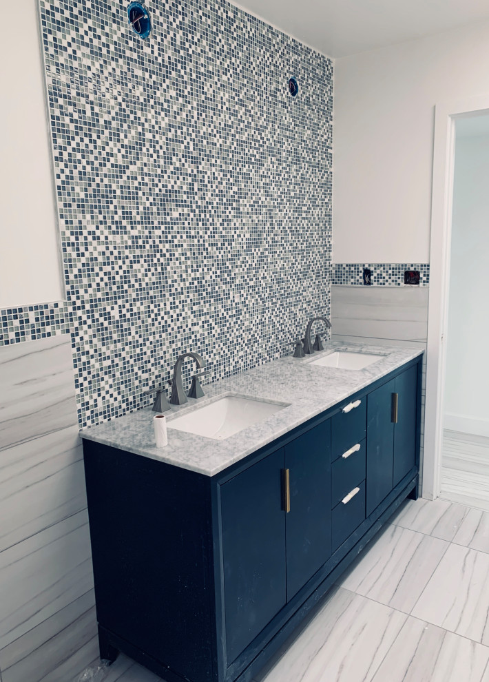 Design ideas for a modern kids bathroom with blue cabinets, gray tile, glass tile, porcelain floors, an undermount sink, marble benchtops, grey floor, white benchtops, a double vanity, a freestanding vanity and decorative wall panelling.