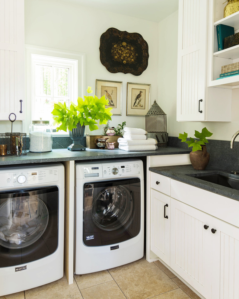 Design ideas for a country l-shaped laundry room in Philadelphia with an undermount sink, recessed-panel cabinets, white cabinets, white walls, a side-by-side washer and dryer, brown floor and grey benchtop.