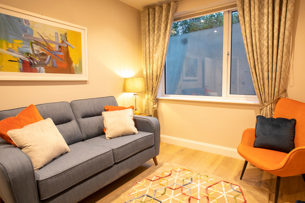 Idée de décoration pour un salon minimaliste avec un mur beige et sol en stratifié.