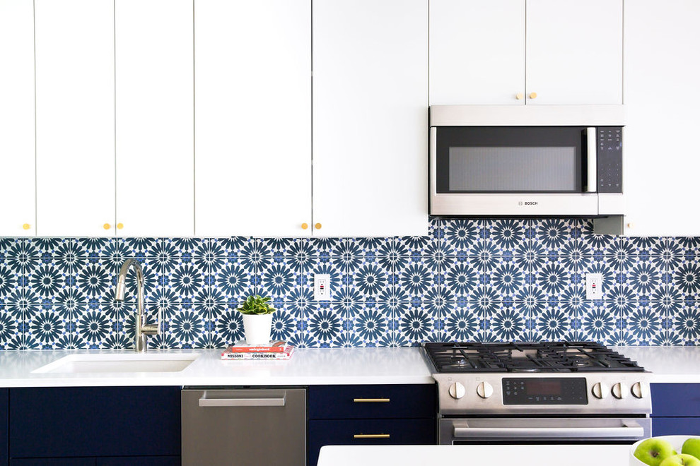 Photo of a mid-sized modern single-wall open plan kitchen in New York with an undermount sink, flat-panel cabinets, blue cabinets, quartz benchtops, blue splashback, cement tile splashback, stainless steel appliances, porcelain floors, with island, grey floor and white benchtop.