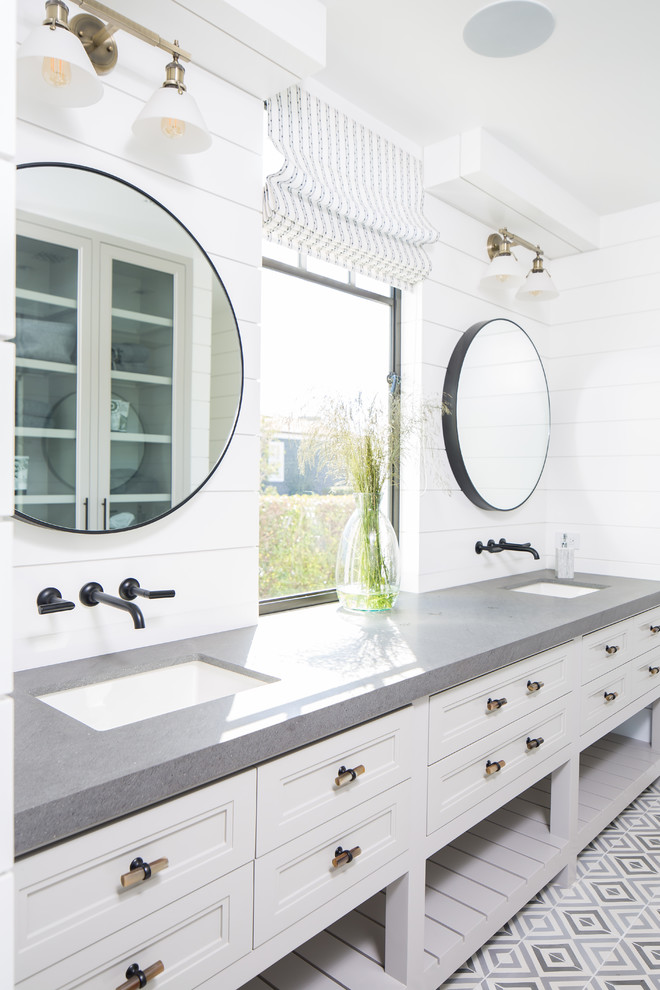 This is an example of a beach style bathroom in Orange County with recessed-panel cabinets, white cabinets, white walls, an undermount sink, grey floor and grey benchtops.