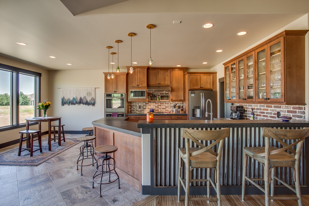 Photo of a country u-shaped eat-in kitchen in Seattle with shaker cabinets, medium wood cabinets, red splashback, brick splashback, stainless steel appliances and black benchtop.