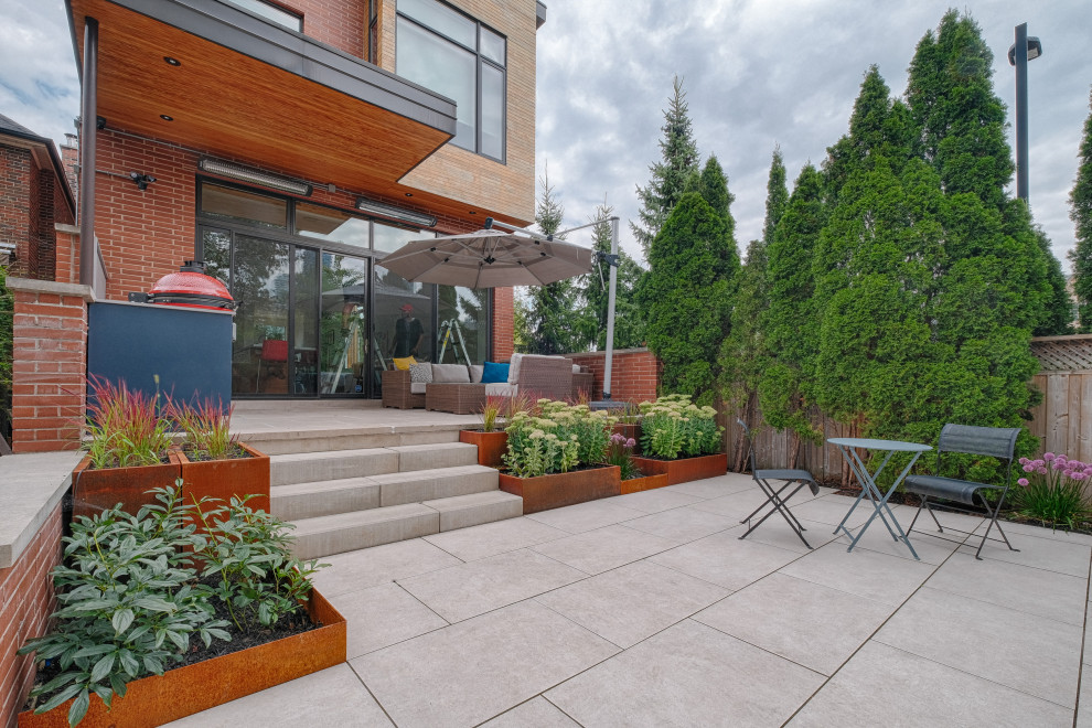 Inspiration for a small contemporary back patio in Toronto with a potted garden and tiled flooring.