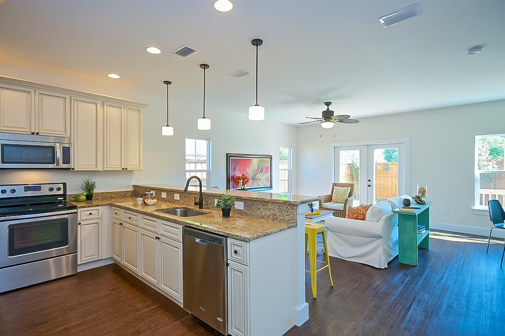 Design ideas for a small beach style u-shaped open plan kitchen in Jacksonville with an undermount sink, raised-panel cabinets, white cabinets, granite benchtops, stainless steel appliances, bamboo floors and a peninsula.