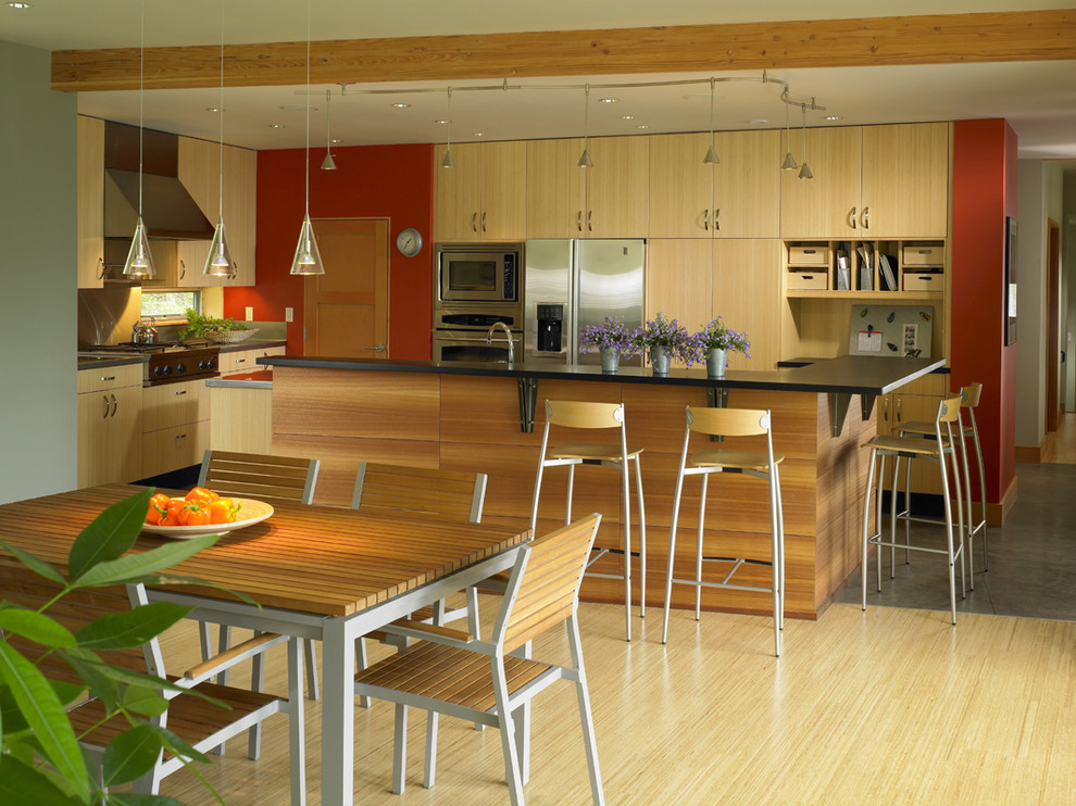 Photo of a contemporary eat-in kitchen in Seattle with stainless steel appliances, flat-panel cabinets and light wood cabinets.