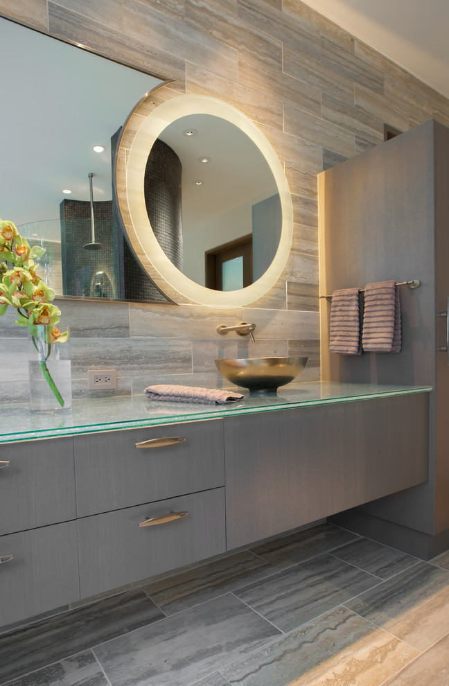 Design ideas for a contemporary bathroom in Dallas with a vessel sink, flat-panel cabinets, grey cabinets, glass benchtops, a freestanding tub, a curbless shower and travertine.