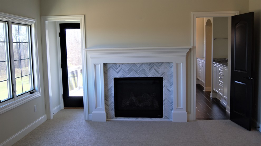 Inspiration for a mid-sized transitional master bedroom in Columbus with beige walls, carpet, a standard fireplace and a tile fireplace surround.