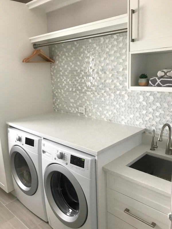 Photo of a mid-sized single-wall laundry room in Chicago with an utility sink, shaker cabinets, white cabinets, quartz benchtops, grey walls, ceramic floors, a side-by-side washer and dryer, grey floor and white benchtop.