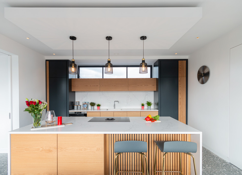 This is an example of a large contemporary galley kitchen in Other with an undermount sink, flat-panel cabinets, medium wood cabinets, white splashback, panelled appliances, with island, grey floor and white benchtop.