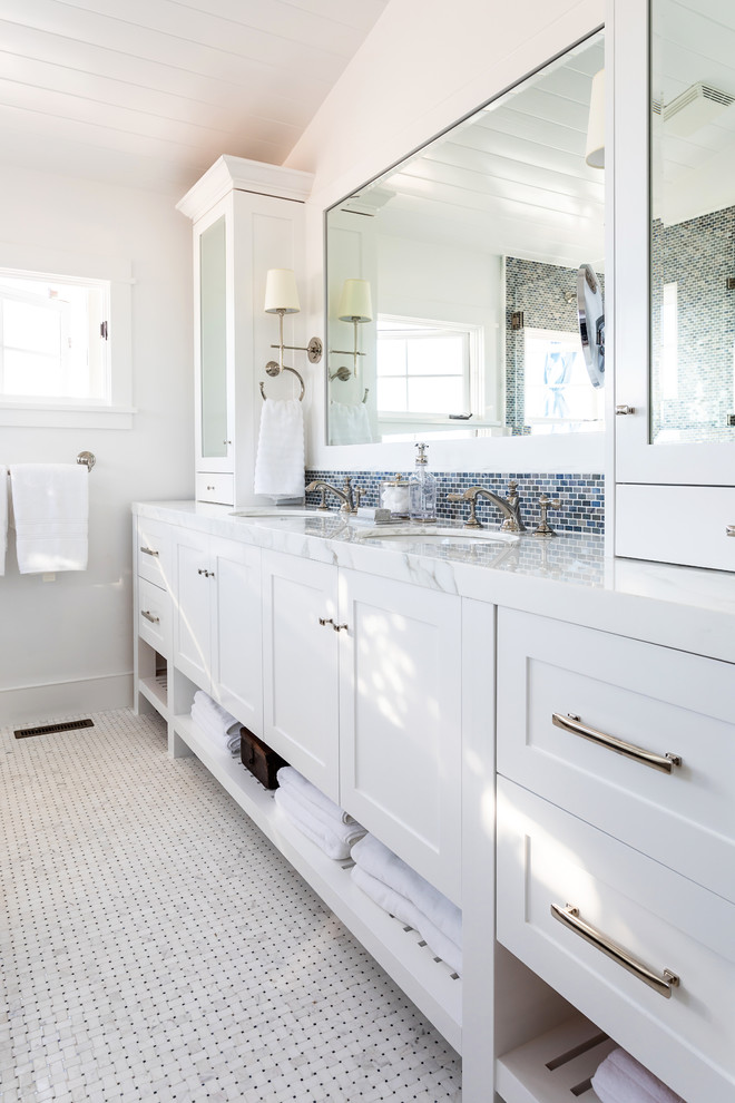 Inspiration for a mid-sized beach style master wet room bathroom in Sacramento with shaker cabinets, white cabinets, a drop-in tub, black tile, white walls, mosaic tile floors, an undermount sink, engineered quartz benchtops, a sliding shower screen and white benchtops.