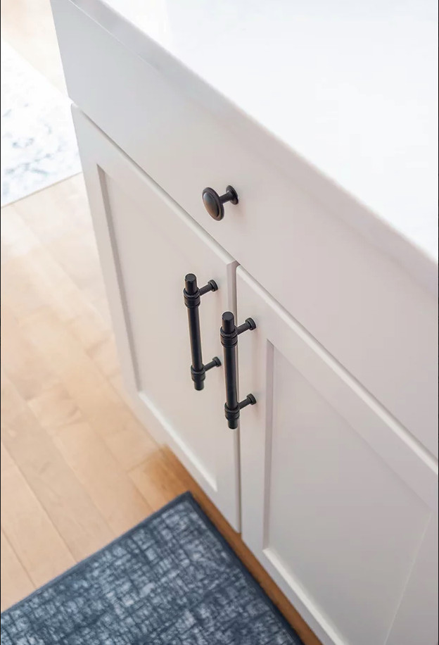 Eat-in kitchen - large transitional u-shaped medium tone wood floor and brown floor eat-in kitchen idea in Minneapolis with a single-bowl sink, shaker cabinets, white cabinets, quartz countertops, white backsplash, porcelain backsplash, stainless steel appliances, an island and white countertops