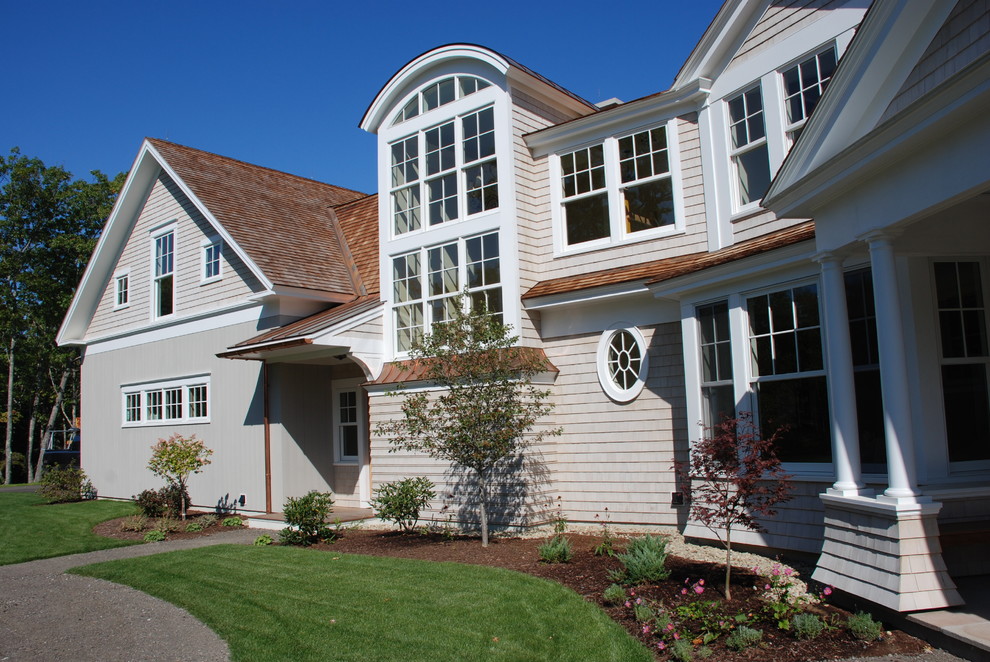 This is an example of an expansive traditional three-storey grey exterior in Portland Maine with wood siding and a gambrel roof.