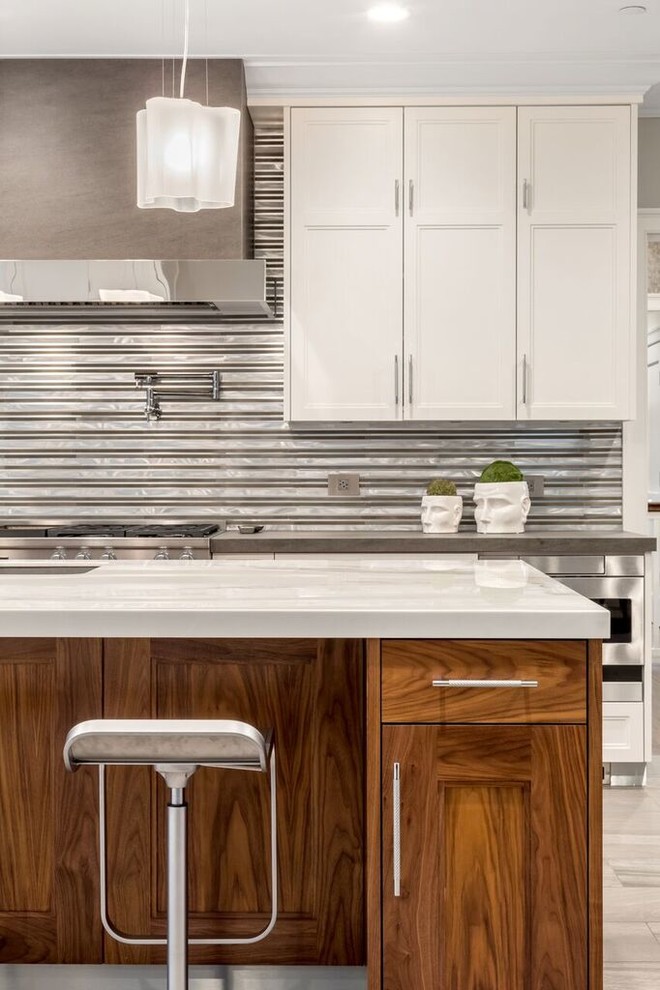 Eat-in kitchen - large transitional galley porcelain tile eat-in kitchen idea in New York with a double-bowl sink, shaker cabinets, white cabinets, marble countertops, multicolored backsplash, porcelain backsplash, stainless steel appliances and an island