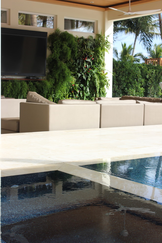Inspiration for a mid-sized modern backyard garden in Miami with natural stone pavers.