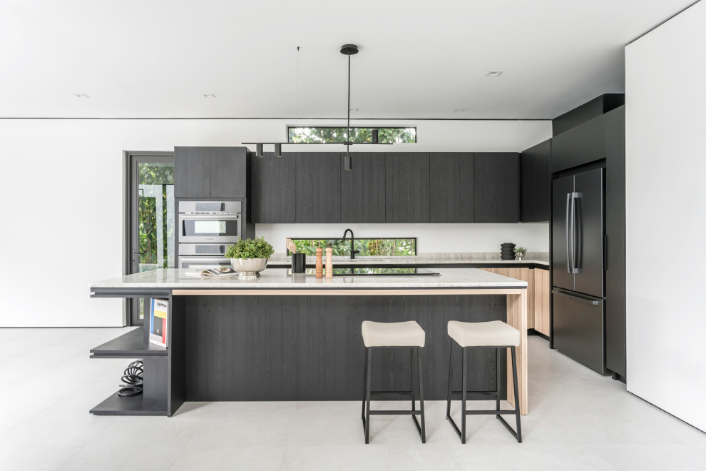Photo of a mid-sized contemporary u-shaped eat-in kitchen in Miami with a single-bowl sink, flat-panel cabinets, black cabinets, onyx benchtops, beige splashback, marble splashback, black appliances, ceramic floors, with island, grey floor and beige benchtop.