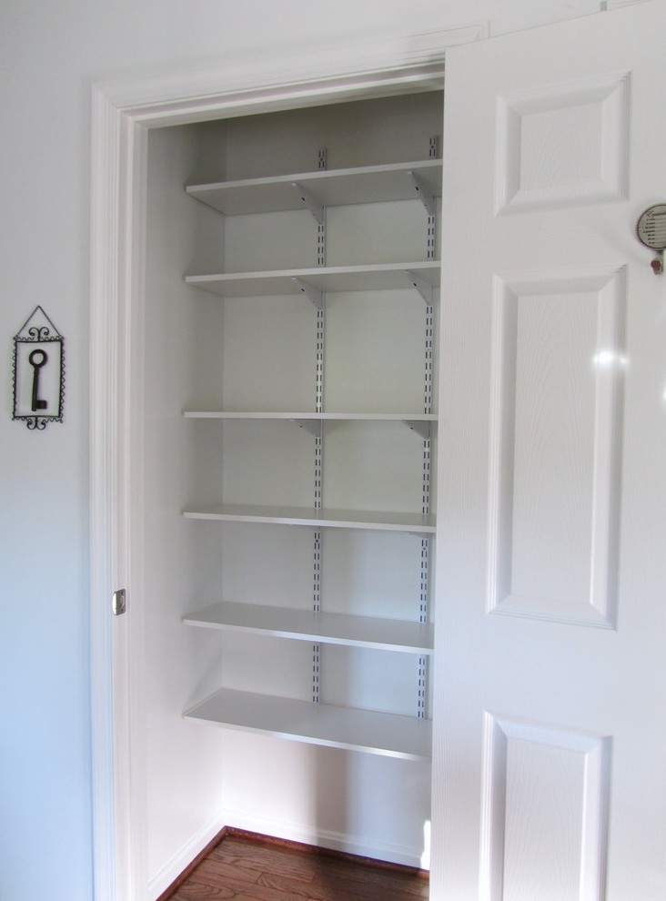 This is an example of a small transitional gender-neutral built-in wardrobe in Boston with open cabinets and white cabinets.