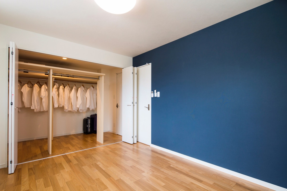 Réalisation d'un dressing minimaliste de taille moyenne et neutre avec un placard sans porte, parquet clair, un sol beige et un plafond en papier peint.