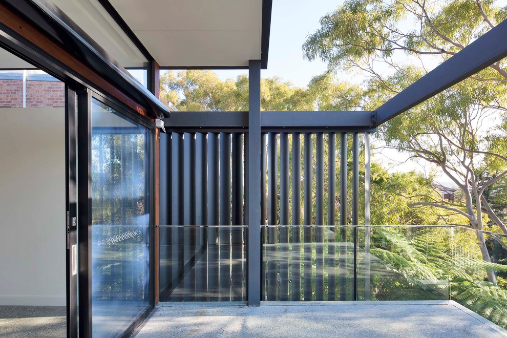 Inspiration for a contemporary balcony in Sydney with glass railing.