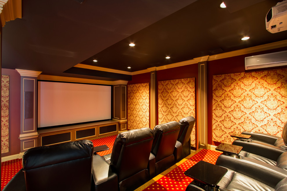 This is an example of a mid-sized traditional enclosed home theatre in New York with red walls, carpet, a projector screen and red floor.