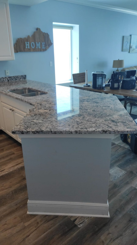 This is an example of a large beach style kitchen in Other with white cabinets, granite benchtops, white appliances and multi-coloured benchtop.