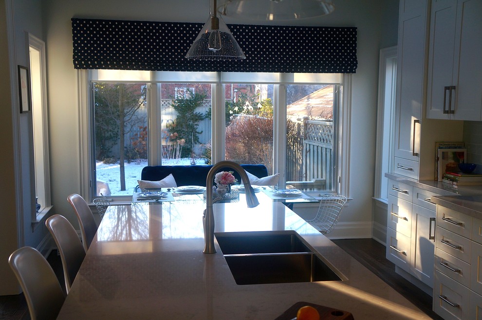 Inspiration for a transitional galley dark wood floor kitchen remodel in Toronto with an undermount sink, shaker cabinets, white cabinets, quartz countertops, blue backsplash, glass tile backsplash, stainless steel appliances and an island