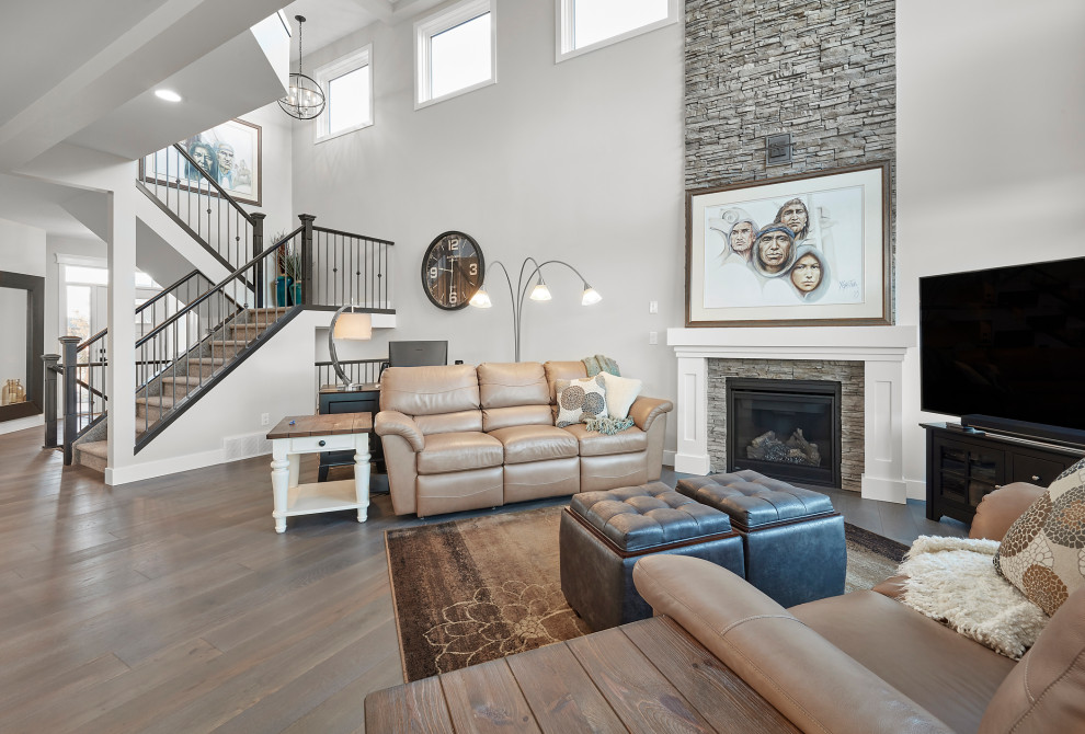 Inspiration for a large contemporary formal and open concept medium tone wood floor, brown floor and coffered ceiling living room remodel in Edmonton with beige walls, a standard fireplace, a stone fireplace and a tv stand