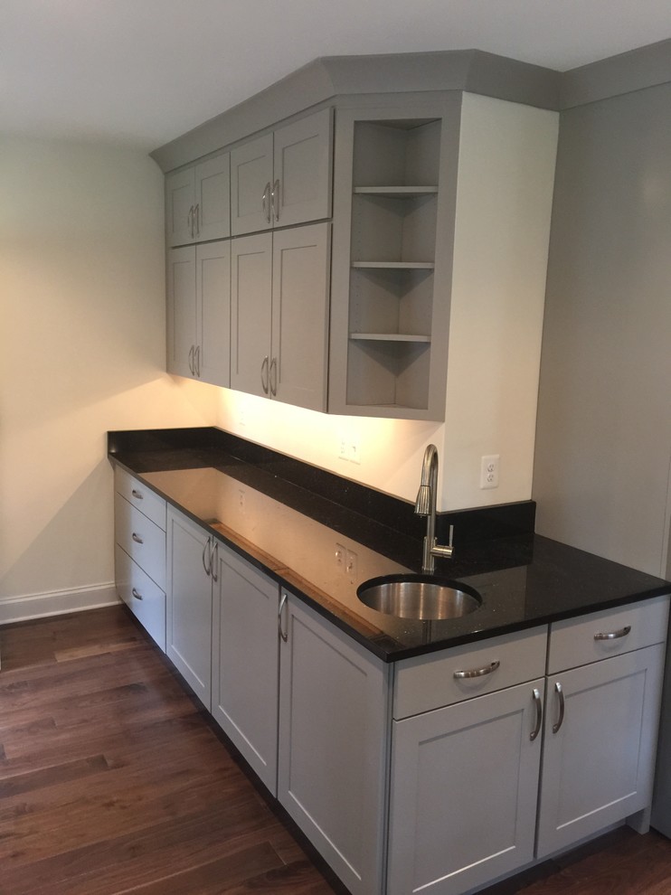 Inspiration for a large transitional l-shaped dark wood floor eat-in kitchen remodel in Baltimore with stainless steel appliances, an undermount sink, shaker cabinets, white cabinets, marble countertops, gray backsplash, stone slab backsplash and an island