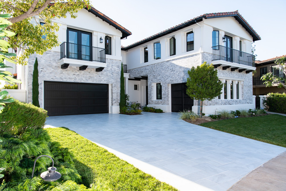 Zweistöckiges Mediterranes Einfamilienhaus mit Steinfassade, weißer Fassadenfarbe, Ziegeldach und rotem Dach in Orange County