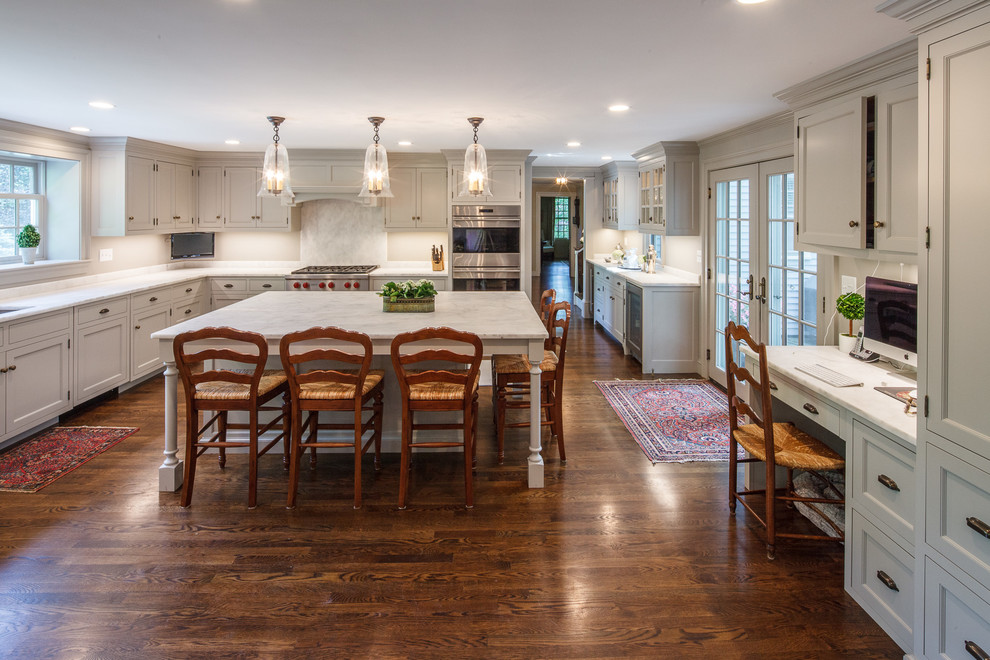 Kitchen - large transitional l-shaped dark wood floor kitchen idea in Boston with a single-bowl sink, beaded inset cabinets, gray cabinets, marble countertops, gray backsplash, stone slab backsplash, paneled appliances and an island