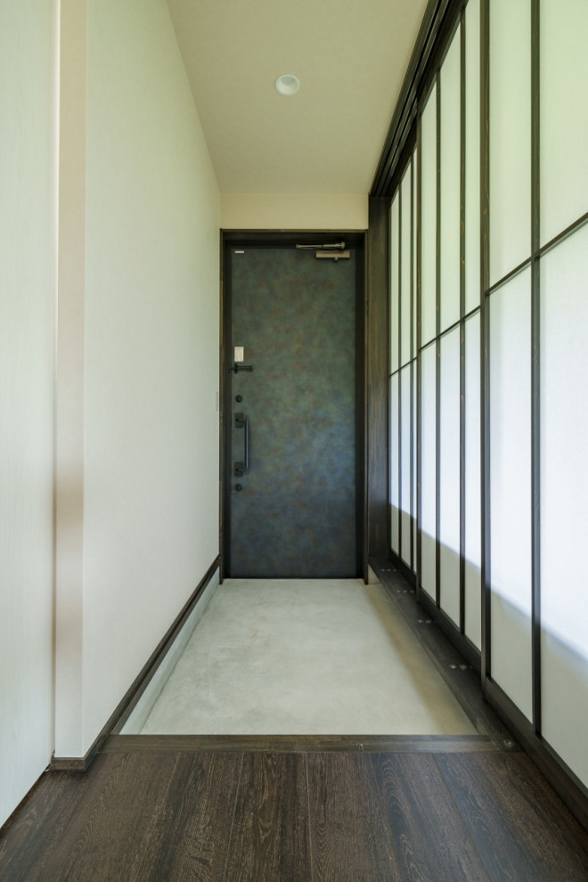 Cette image montre une porte d'entrée minimaliste de taille moyenne avec un mur blanc, parquet foncé, une porte simple, une porte grise, un sol marron, un plafond en papier peint et du papier peint.