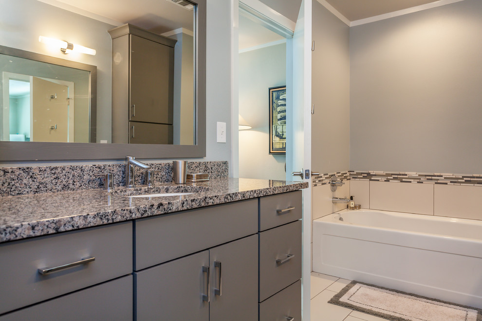 Inspiration for a mid-sized contemporary master bathroom in Dallas with an undermount sink, flat-panel cabinets, grey cabinets, granite benchtops, an alcove tub, a corner shower, a two-piece toilet, white tile, ceramic tile, grey walls and ceramic floors.