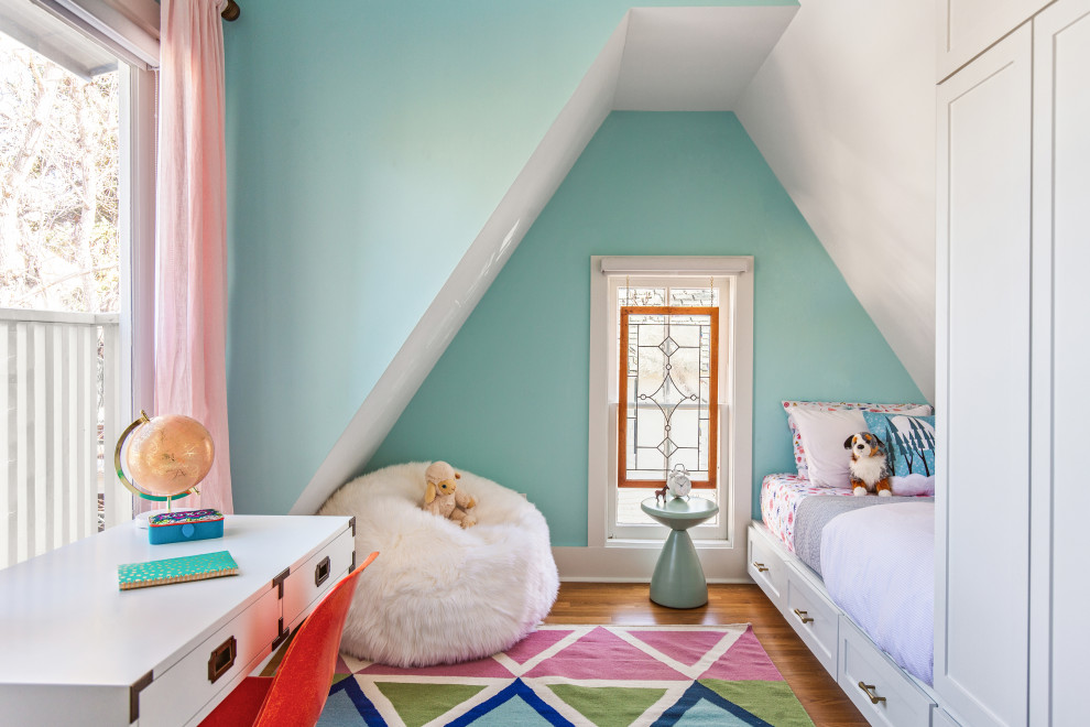 Photo of a transitional kids' bedroom for girls in Denver with blue walls, medium hardwood floors, brown floor and vaulted.
