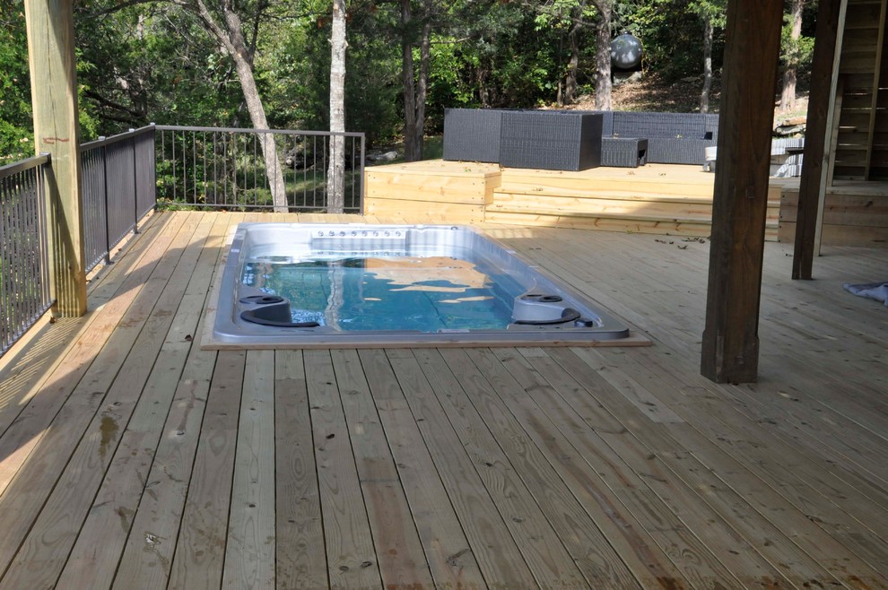 Small country backyard rectangular pool in Other with a hot tub and decking.