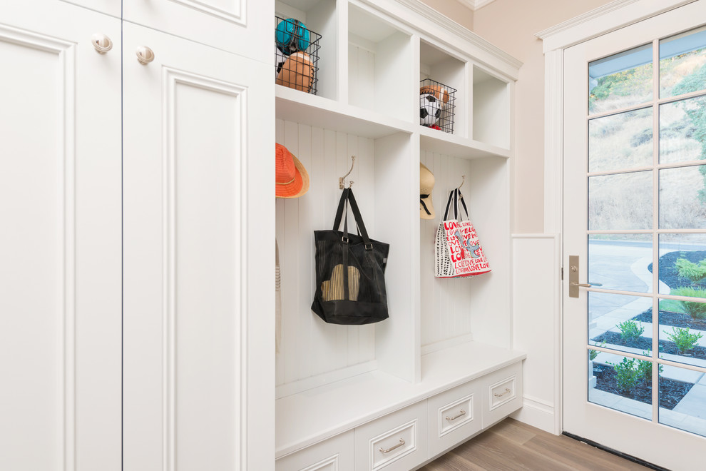 This is an example of a traditional mudroom in San Francisco with grey walls, medium hardwood floors, a single front door and a white front door.