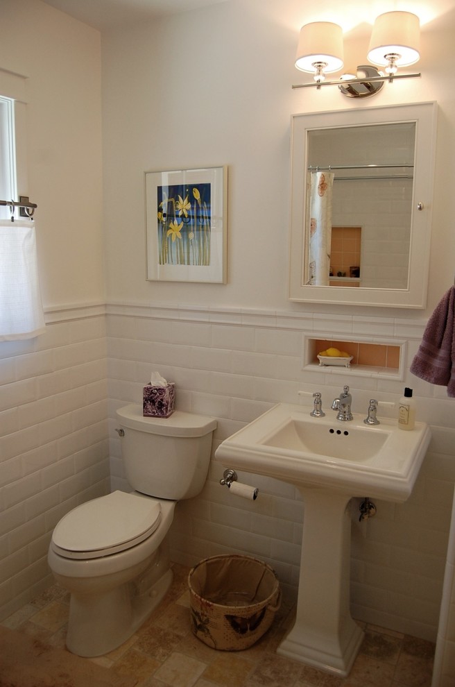 This is an example of a small traditional bathroom in Orange County with a pedestal sink, recessed-panel cabinets, white cabinets, a claw-foot tub, an open shower, a two-piece toilet, beige tile, stone tile, white walls and travertine floors.