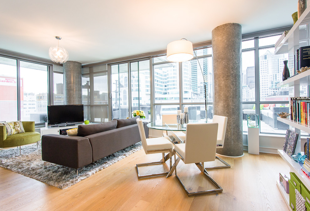 This is an example of a contemporary open concept living room in Toronto with a freestanding tv.
