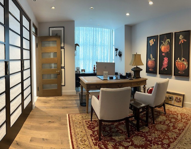 Mittelgroßes Asiatisches Arbeitszimmer mit Arbeitsplatz, weißer Wandfarbe, braunem Holzboden, freistehendem Schreibtisch und braunem Boden in Los Angeles
