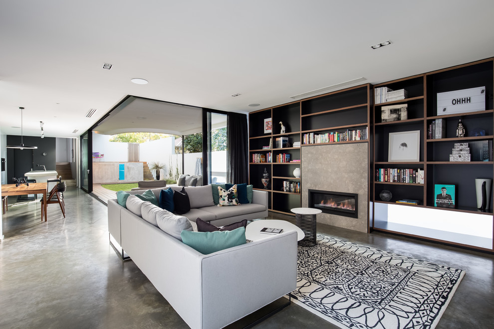 Design ideas for a contemporary open concept family room in Perth with a library, black walls, concrete floors, a ribbon fireplace, a metal fireplace surround and grey floor.